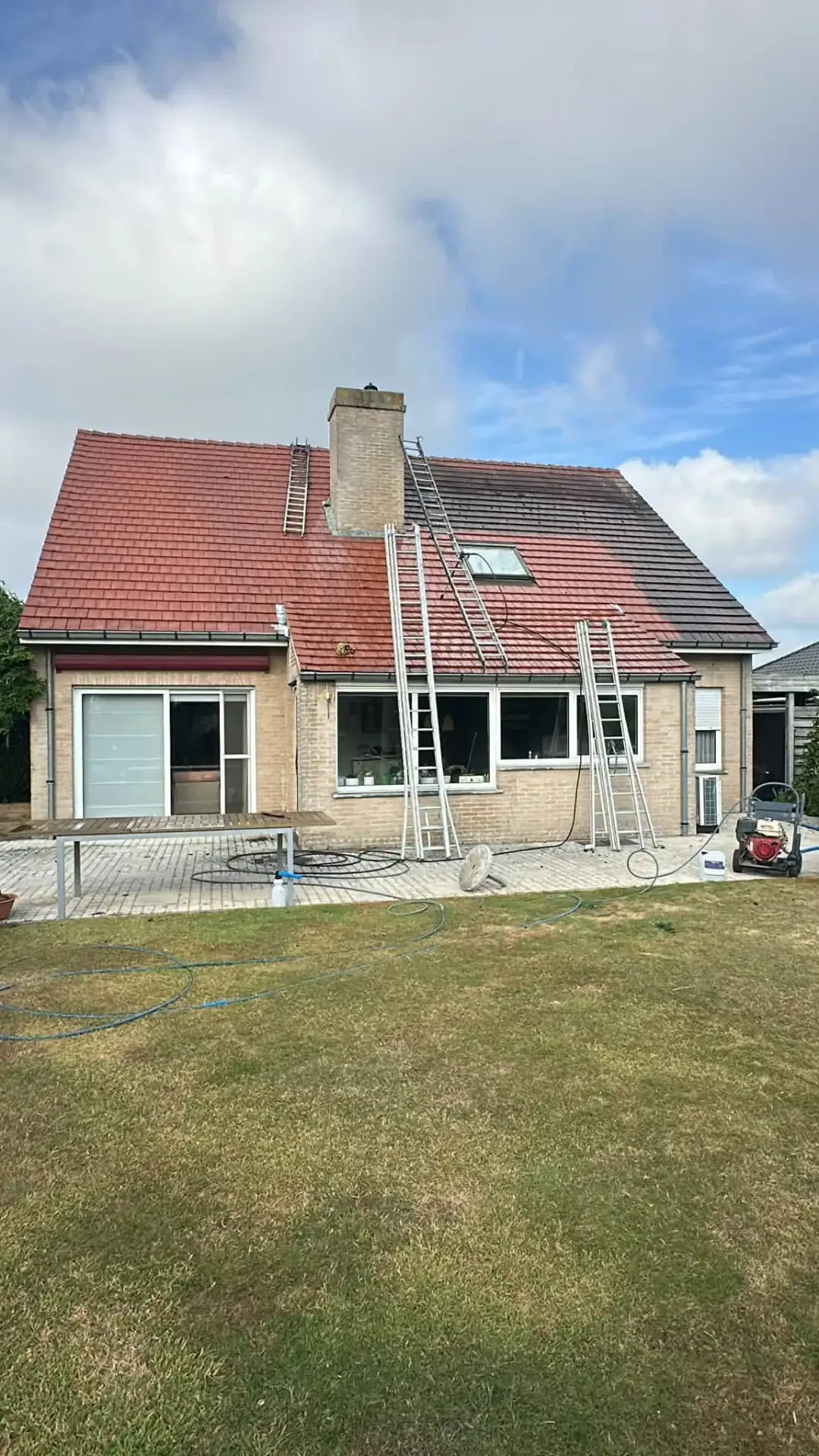 Woning met rode dakpannen: links al gereinigd, rechts nog vervuild