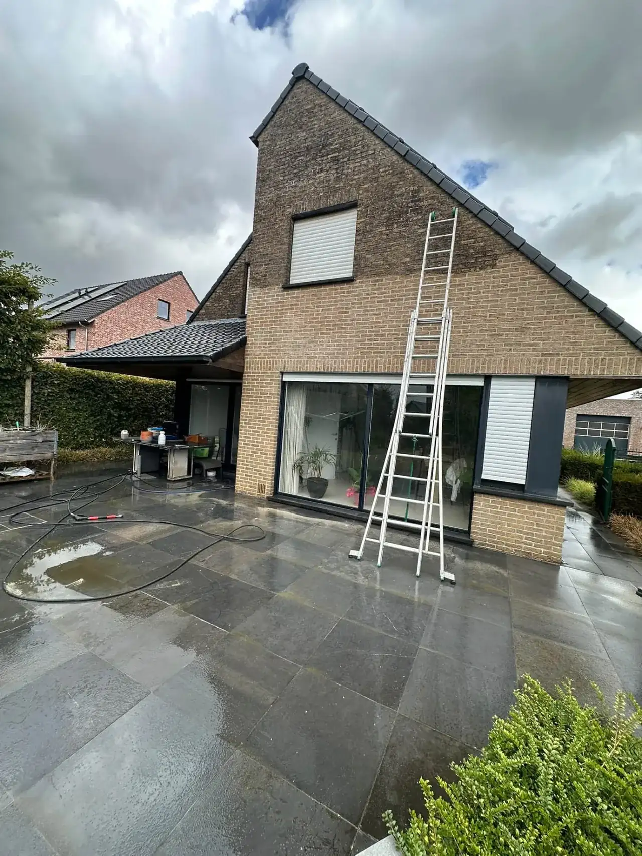 Gevelreiniging aan de puntgevel met de ladder tegen de gevel
