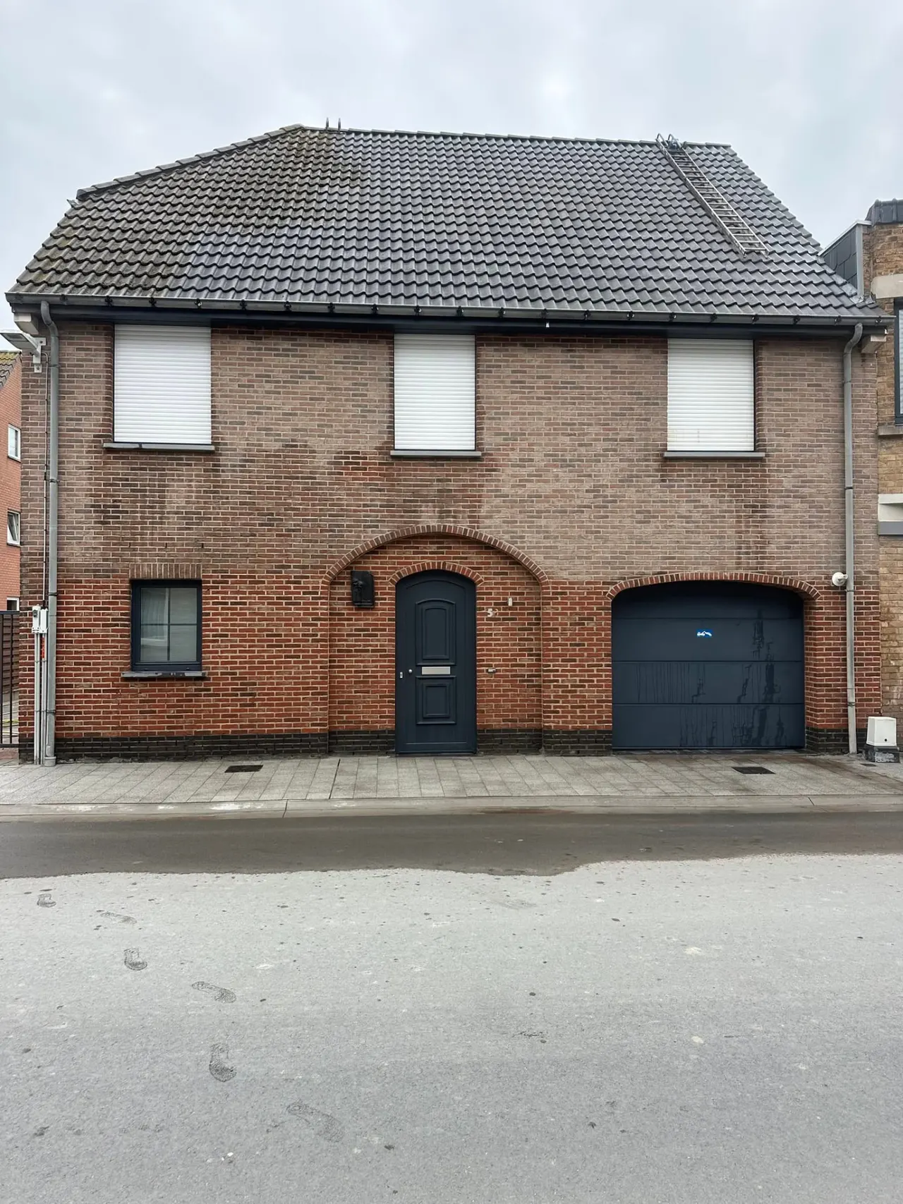Bakstenen woning met vervuilde gevel voor reiniging en hydrofugebehandeling